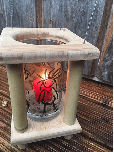 Eine Tischlaterne aus Bambusholz mit einer roten Kerze