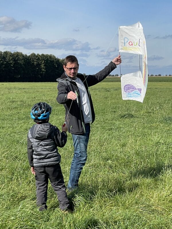 Vater und Sohn lassen einen selbstgebauten Drachen fliegen